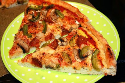 To pizzastykker på limegrønn tallerken med hvite prikker